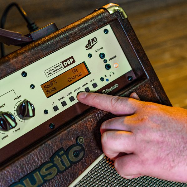 close up of a person turning on the Digital effects of A40 40W acoustic amp